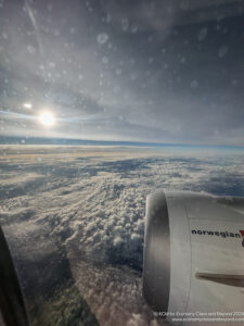 a view of clouds and the sun from an airplane window