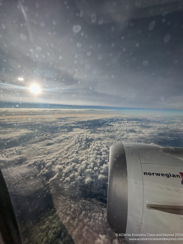 a view of clouds and the sun from an airplane window