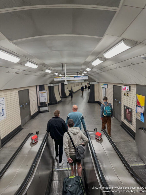 a group of people walking down an escalator