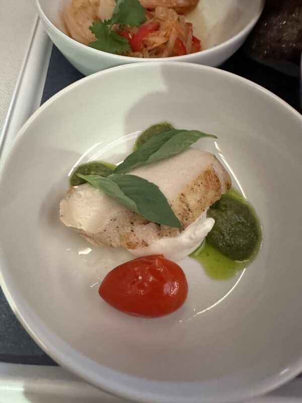 a plate of food with a tomato and basil leaf