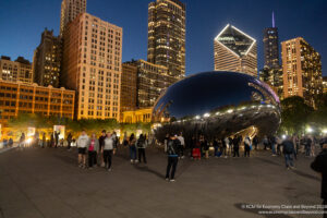 a group of people standing around a large reflective object in Millennium Park