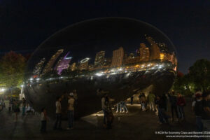 a group of people standing around a large reflective object