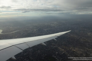 an airplane wing and city view from an airplane window