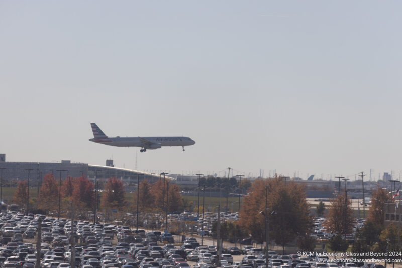 an airplane flying over a parking lot