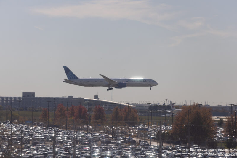 a plane flying over a parking lot