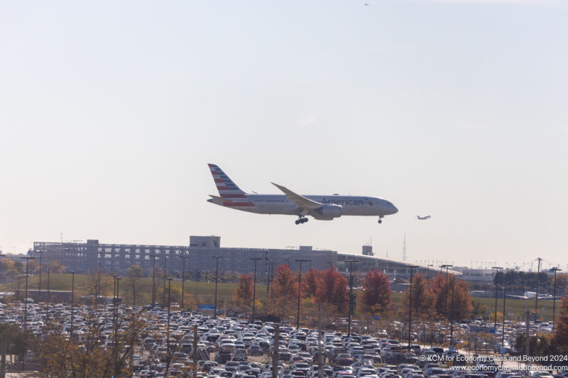 an airplane flying over a parking lot