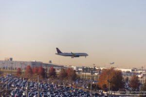 an airplane flying over a parking lot