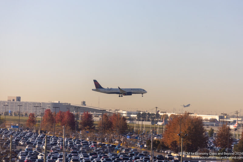 an airplane flying over a parking lot