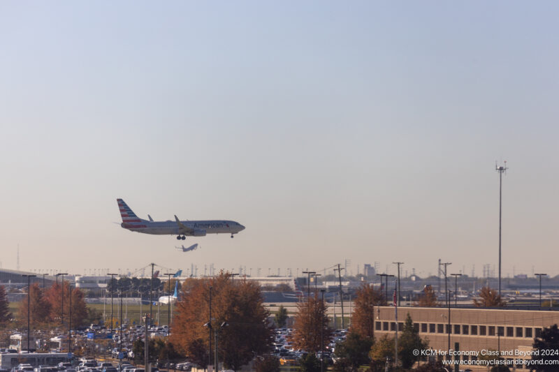 an airplane flying over a runway