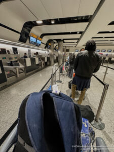 a person standing in a line with luggage