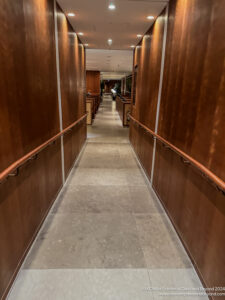 a long hallway with wooden walls and railings