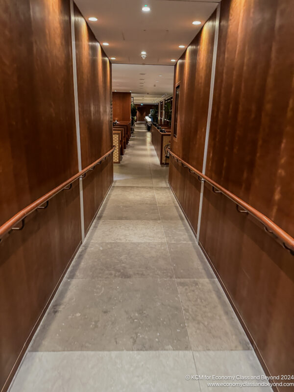 a long hallway with wooden walls and railings