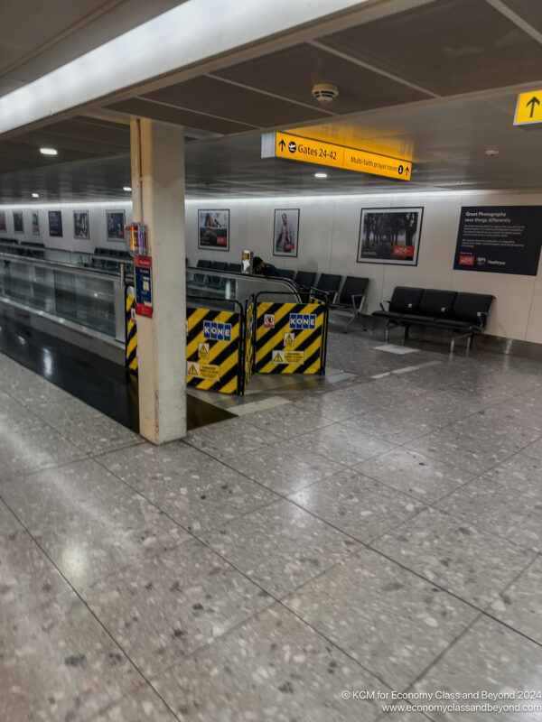 a walkway with benches and signs