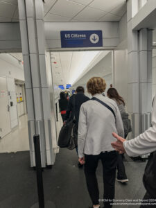 people walking through a building with a sign