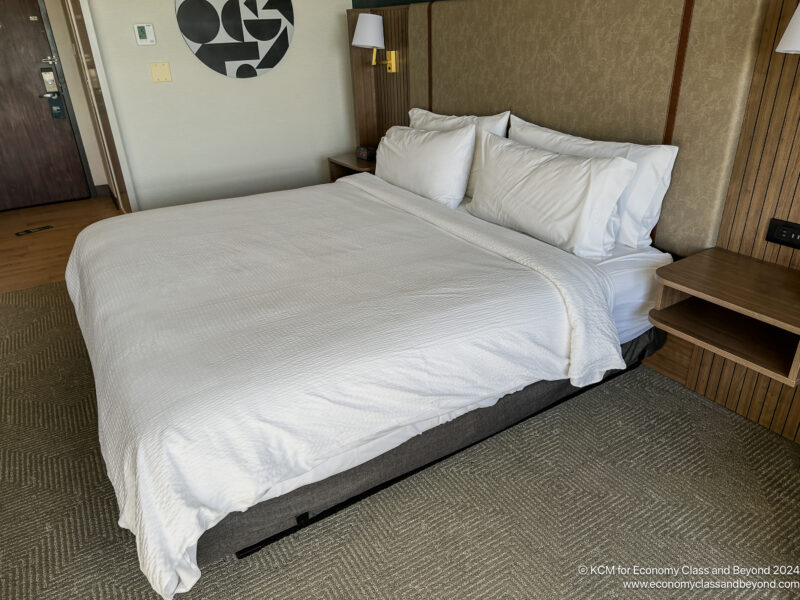 a bed with white sheets and pillows