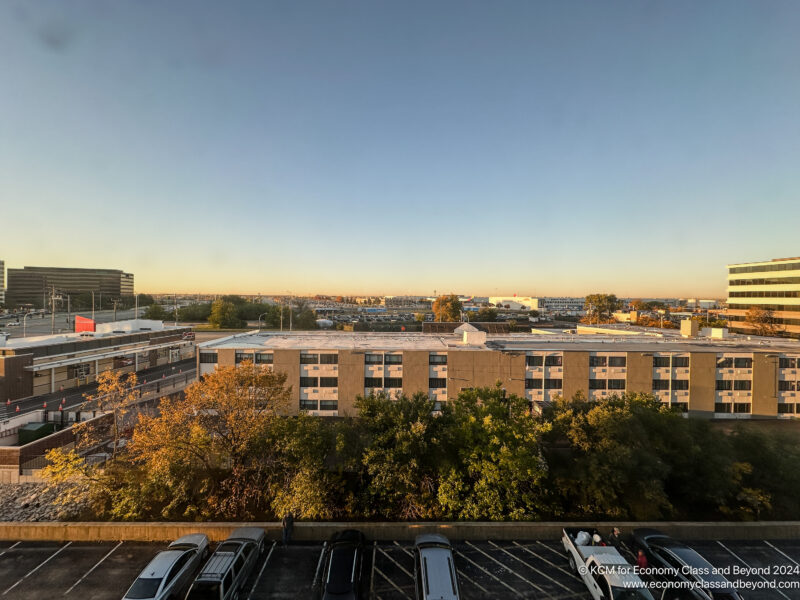 a parking lot with trees in front of it