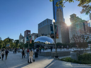 a group of people walking in a park with a large silver dome