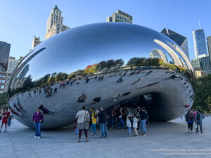 a group of people standing around a large reflective object