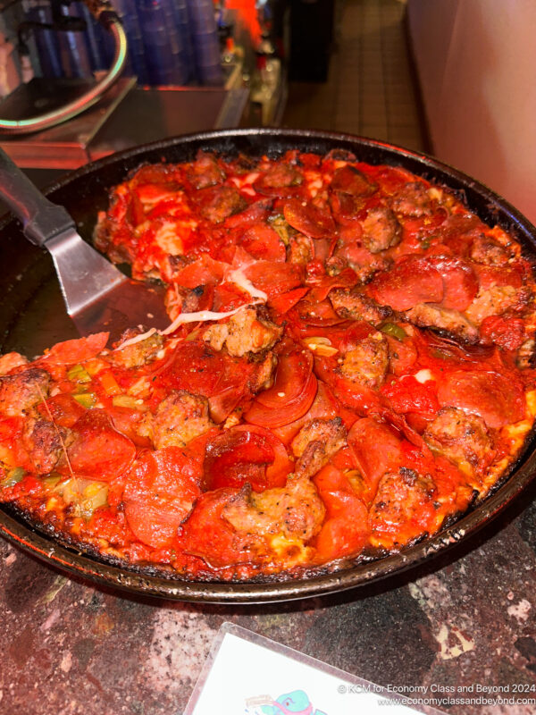 a pizza with meat and vegetables in a pan