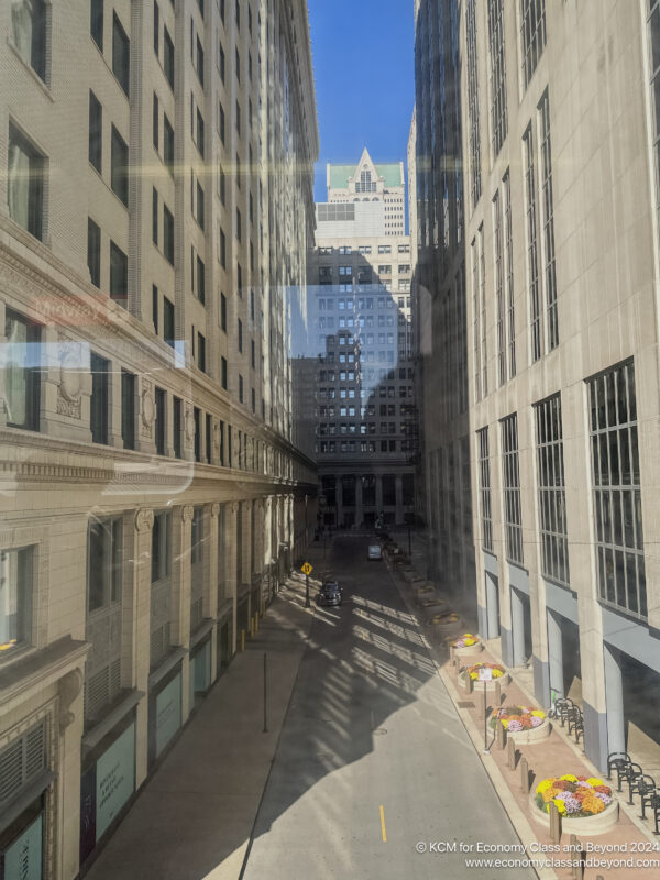 a street between buildings with a car parked on the side