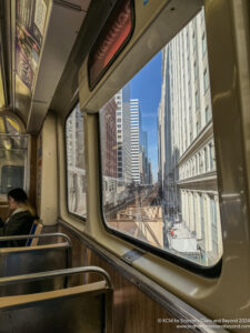 a window of a train with a woman sitting on a bench