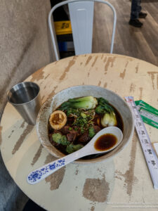 a bowl of soup with a spoon and a measuring cup on a table