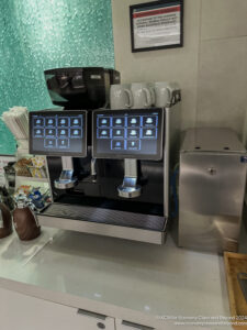 a coffee machine with a screen and a metal container