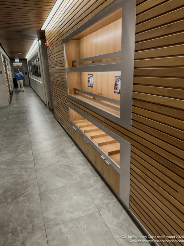 a hallway with shelves and a person walking