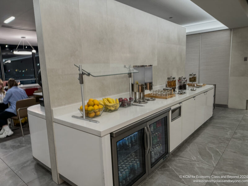 a white counter with fruit and drinks on it