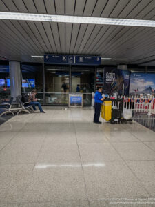 people in an airport with a person standing in front of a cart