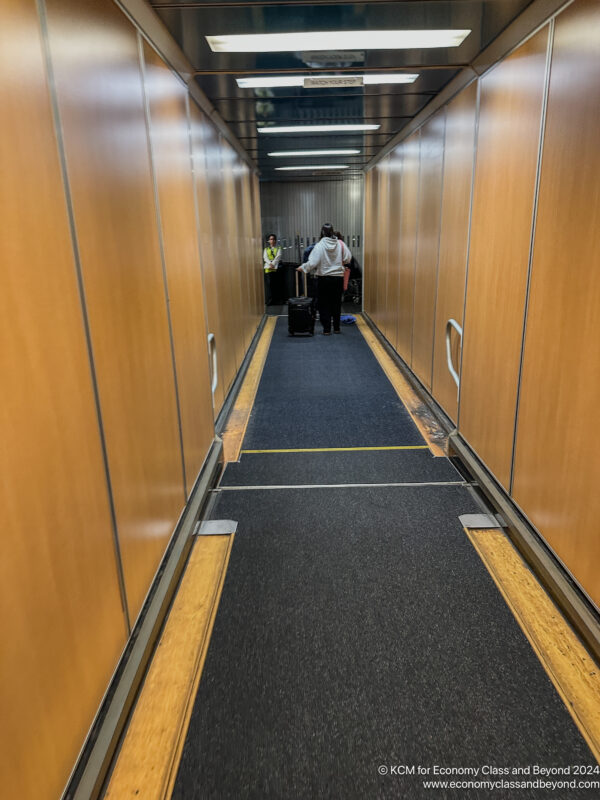 a person walking down a hallway with luggage