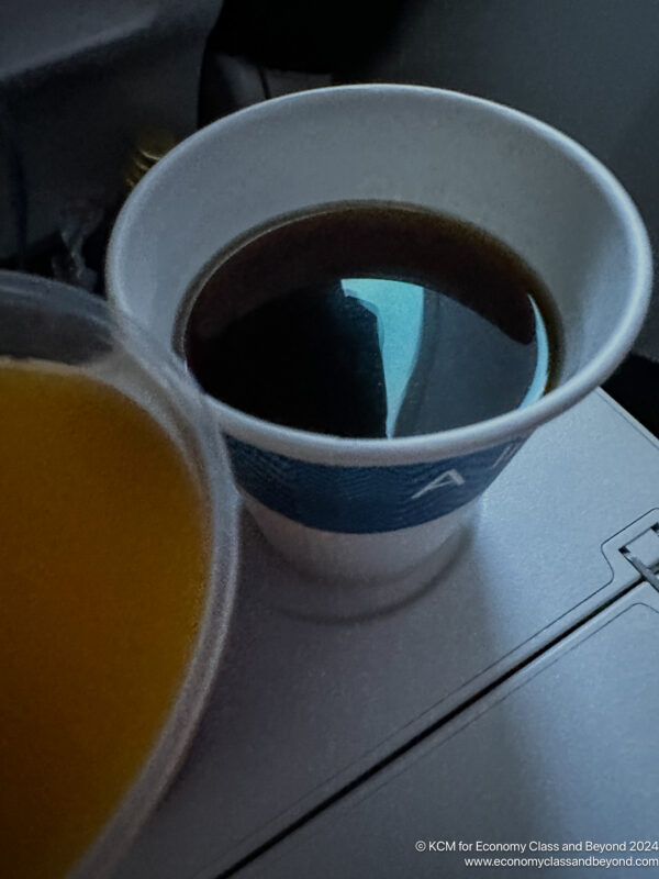 a cup of coffee and a container of orange juice