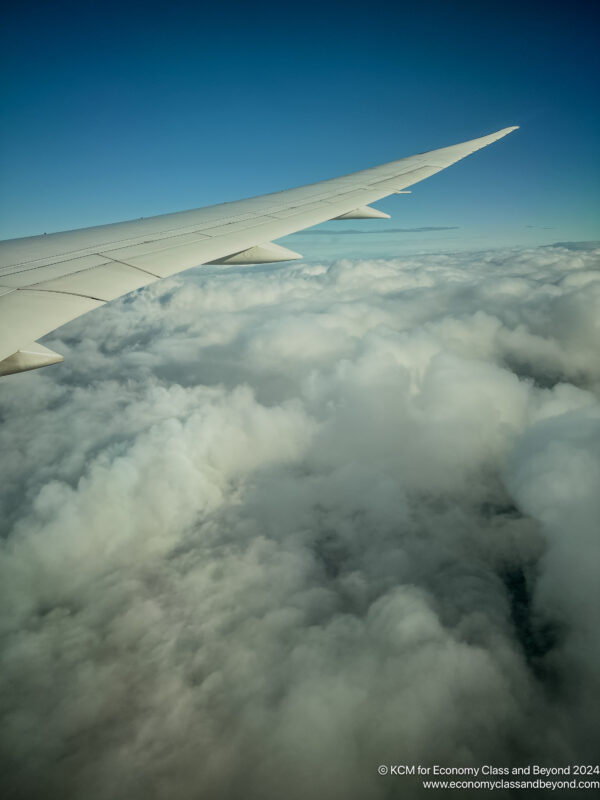 an airplane wing above the clouds