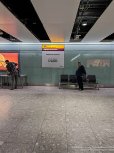 a group of people standing in a room with benches and signs