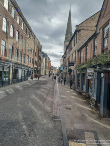 a street with buildings and people walking on it