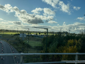 a road with cars and a large field