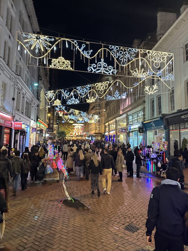 a crowd of people walking on a brick street