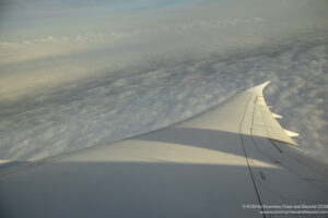 an wing of an airplane above clouds