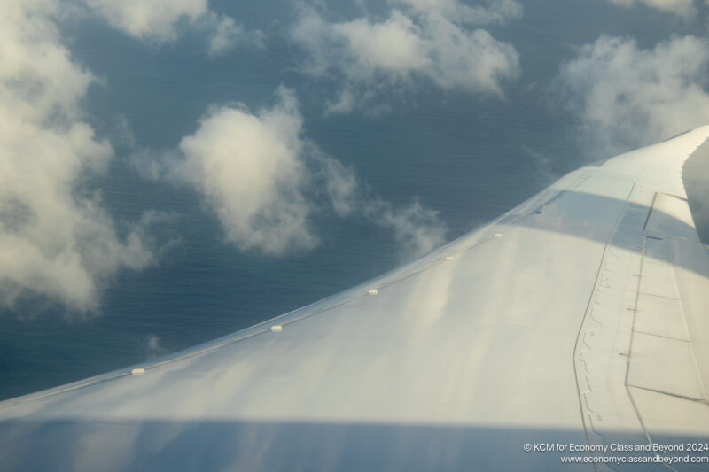 an airplane wing with clouds above