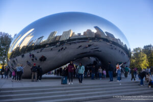 a group of people standing around a reflective object with Millennium Park in the background