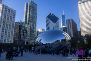 a group of people standing around a large silver object in Millennium Park