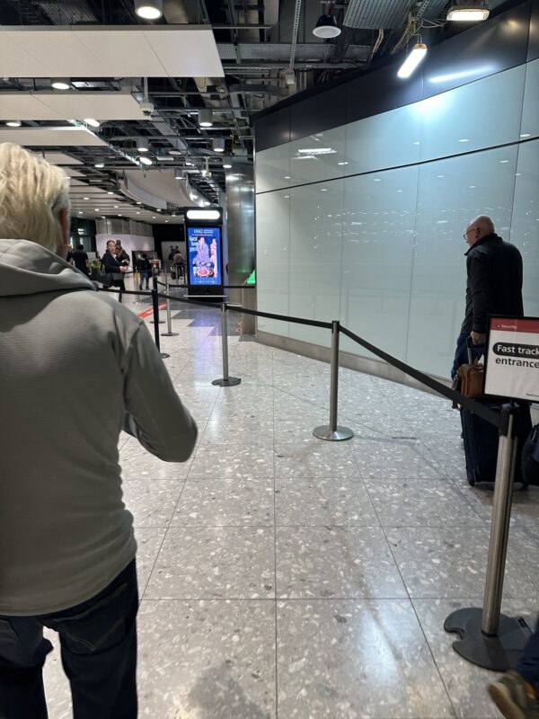 a man standing in a hallway with a sign