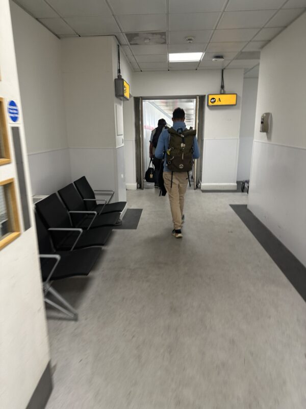 a man walking in a hallway with a backpack