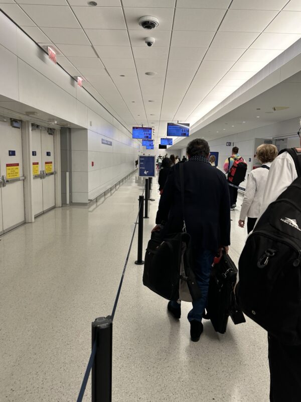 people walking in a hallway with luggage