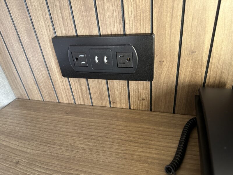 a black outlet on a wood wall