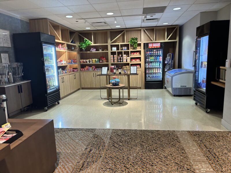 a room with shelves of beverages and a coffee machine