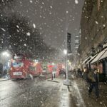 a snow falling on a city street