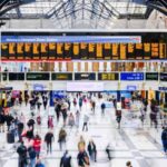 a group of people in a train station with Liverpool Street station in the background