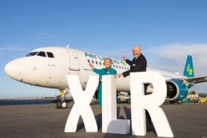 a man and woman standing in front of a large white sign