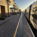 a person walking on a platform next to a train